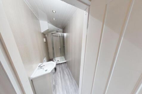 A clean and bright bathroom with a large bathtu...