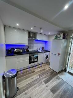 Modern kitchen area featuring sleek white cabin...