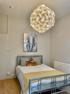 Bright, neatly presented bedroom with a metal d...