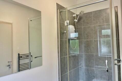 Bright modern bathroom featuring a fully tiled ...