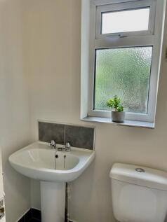 Bright, tidy bathroom with a pedestal sink, mod...