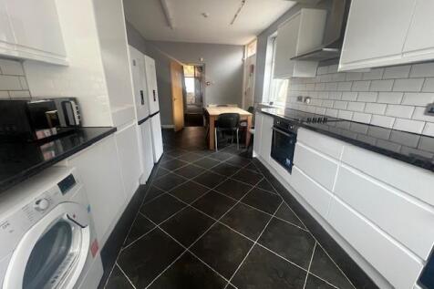 Bright modern galley kitchen with white cabinet...