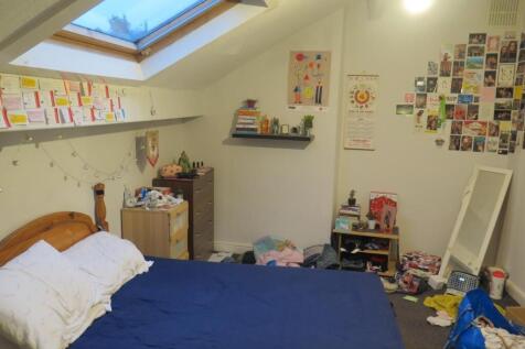 Brightly lit attic double bedroom with a skylig...