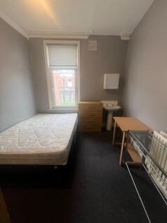 Neutral-painted student bedroom with a single b...