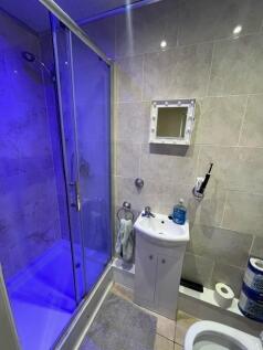 Modern tiled bathroom with a glass shower cubic...