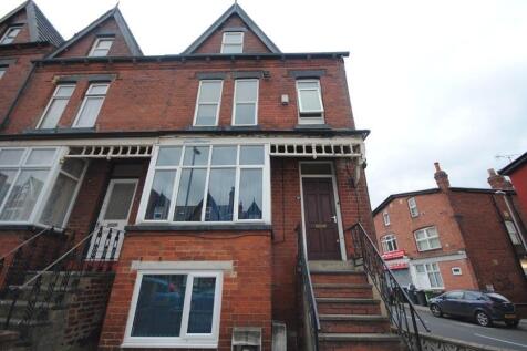 Red-brick terraced property with bay windows, a...