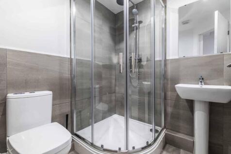 Modern bathroom with a corner glass shower encl...