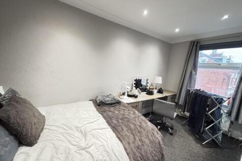 A well-maintained bedroom featuring a cozy doub...