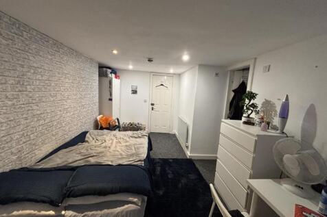 A well-lit bedroom featuring a comfortable doub...