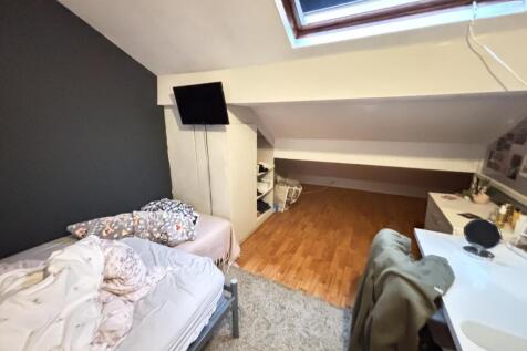 A cozy bedroom with a comfortable bed, a desk, ...