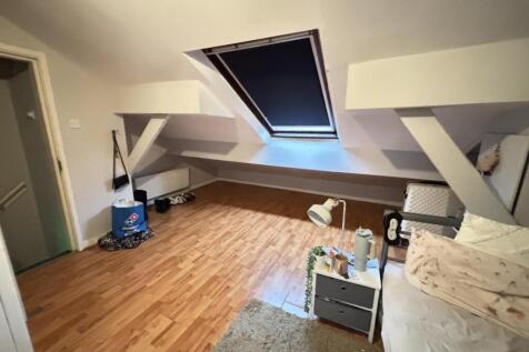 A cozy attic room with a sloped ceiling featuri...