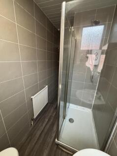 A modern, clean bathroom with neutral tiles and...