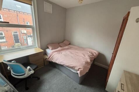 A tidy student bedroom featuring a double bed, ...