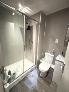 Modern bathroom featuring a spacious shower enc...