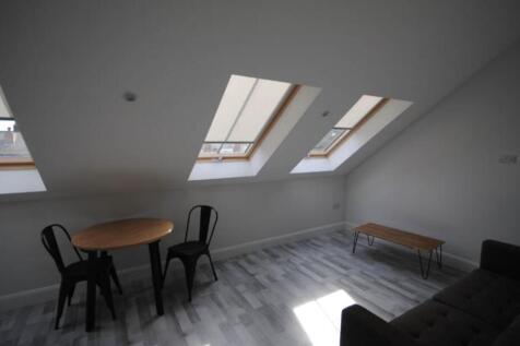 A bright, modern living room with large skyligh...