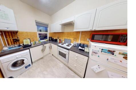 Modern kitchen with white cabinets and applianc...