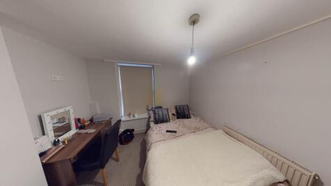 A spacious double bedroom featuring a large bed...