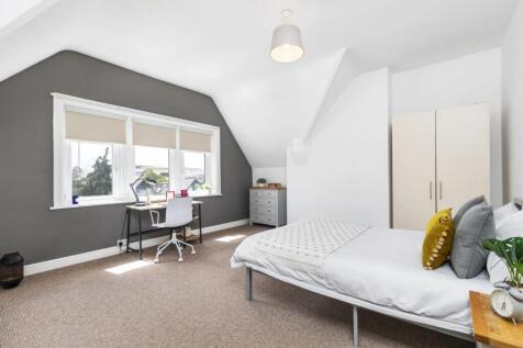 A spacious and well-lit master bedroom featurin...