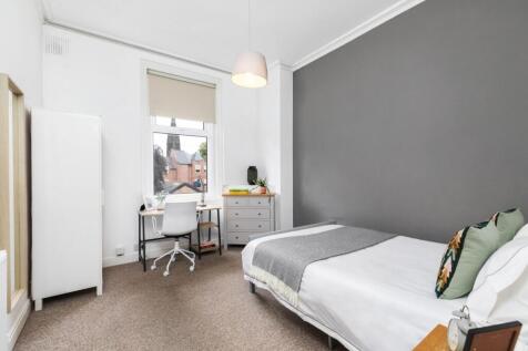 A bright and inviting bedroom featuring a comfo...