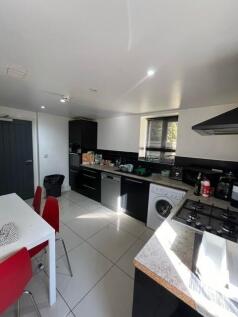 Modern fitted kitchen with black cabinetry, int...