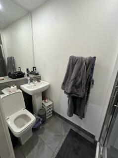 Compact bathroom with tiled floor, pedestal sin...
