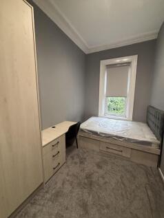 A cozy bedroom with neutral grey walls, a large...