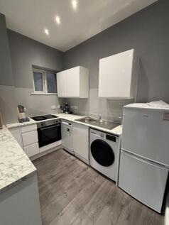 Bright and modern kitchen with ample white cabi...