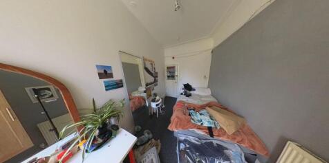 A cozy bedroom with a single bed, a desk, and s...