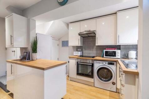Bright modern kitchen with white high-gloss cab...
