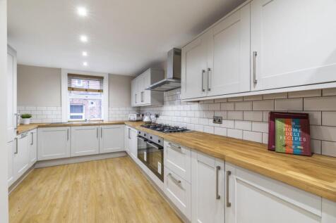 Bright modern kitchen with light wood worktops,...