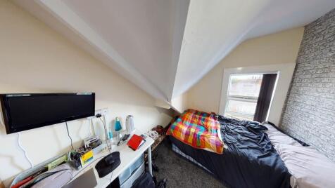 A cozy single bedroom featuring a comfortable b...