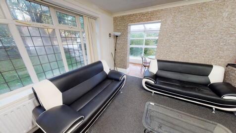 A spacious and well-lit living room featuring m...