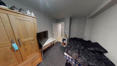 A cozy bedroom featuring a bed, wardrobe, and a...