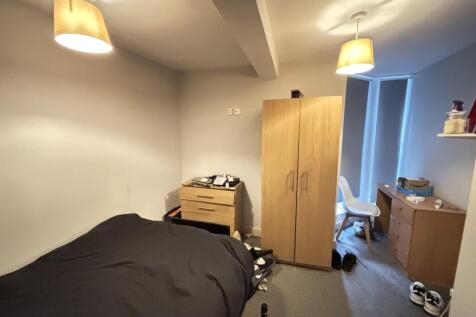 A cozy bedroom featuring a large bed, a small w...