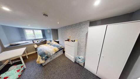 A comfortably furnished bedroom featuring a dou...