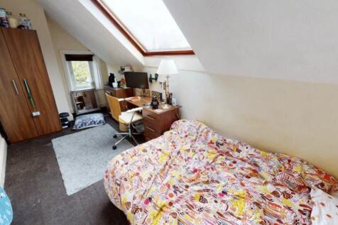 A cozy bedroom featuring a spacious bed with co...