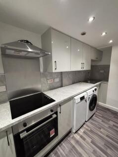 Modern kitchen featuring integrated appliances,...