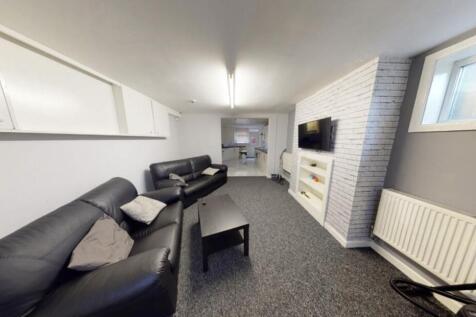 A spacious, well-lit living room featuring comf...