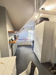 A cozy single bedroom featuring a comfortable b...