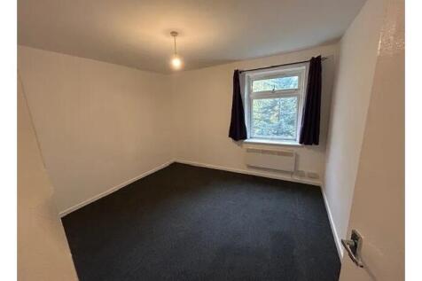 Bright, neutral bedroom with a large window, si...