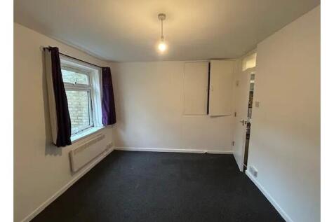 Simple, neutrally decorated bedroom with a wind...