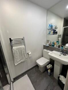 Modern bathroom with a pedestal sink, toilet, l...