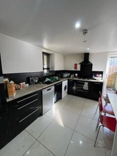 Modern galley-style kitchen with sleek black ca...