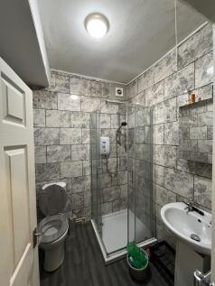 Modern bathroom with grey tiled walls, a shower...