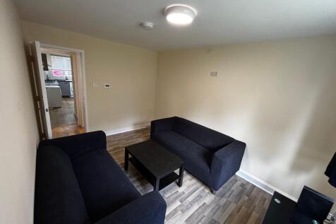 A spacious living room featuring two comfortabl...