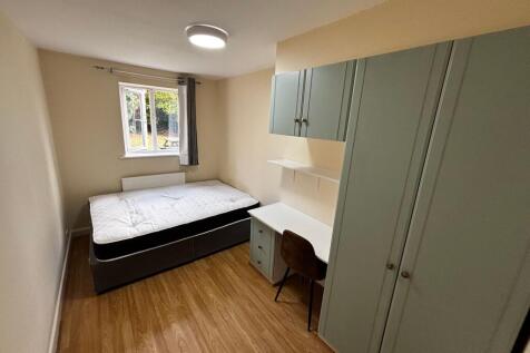 A cozy single bedroom featuring a comfortable b...