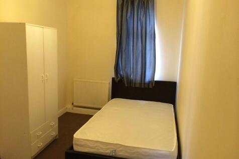 A cozy bedroom featuring a single bed, a wardro...