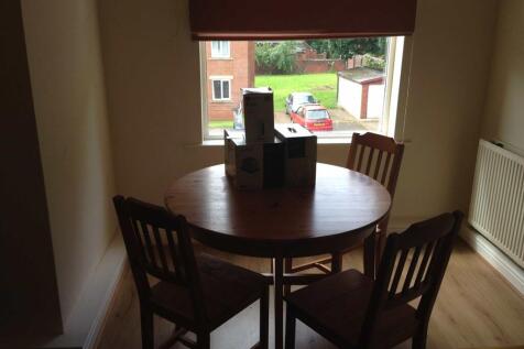 A cozy living room with a wooden table and thre...