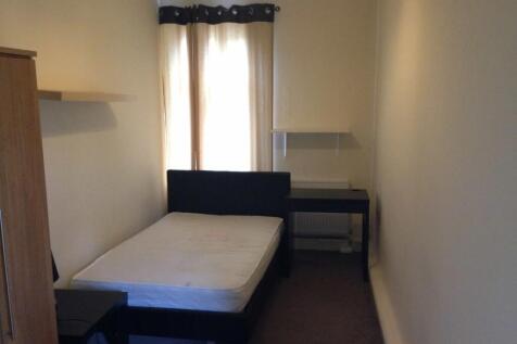 Cozy single bedroom with a simple bed, a window...