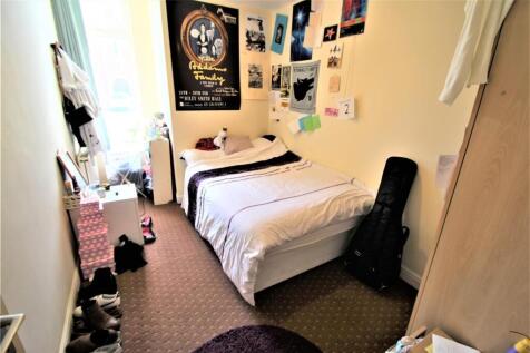 Bright and cozy single bedroom with a neatly ma...